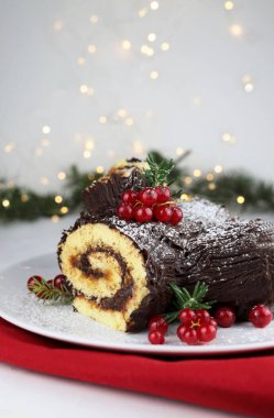 Geleneksel Noel tatlısı. Buche de Noel. Çikolata kremalı ve üzümlü Noel pastası. Tatil sezonu.