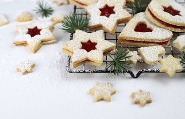 Linzer Noel kurabiyeleri. Beyaz arka planda kıtır hamurlu bisküvi ve ahududu reçeli. Tatil sezonu. Noel süslemesi.