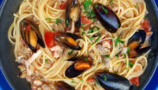 Easy campsite meals, spaghetti with mussels and tomato sauce. Overhead view. Holiday season.