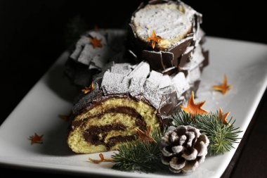 Lezzetli çikolatalı Noel kütüğü, siyah arka planda Buche de Noel. Tatil sezonu. Yakın plan..