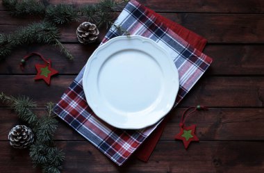 Kırsal ahşap arka planda boş beyaz tabak ile Noel yemeği sınırı. Noel ve tatil sezonu. Genel bakış. Boşluğu kopyala.