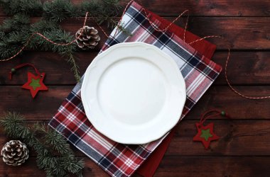Kırsal ahşap arka planda boş beyaz tabak ile Noel yemeği sınırı. Noel ve tatil sezonu. Genel bakış. Boşluğu kopyala.