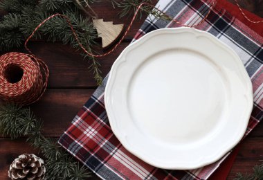 Kırsal ahşap arka planda boş beyaz tabak ile Noel yemeği sınırı. Noel ve tatil sezonu. Genel bakış. Boşluğu kopyala.