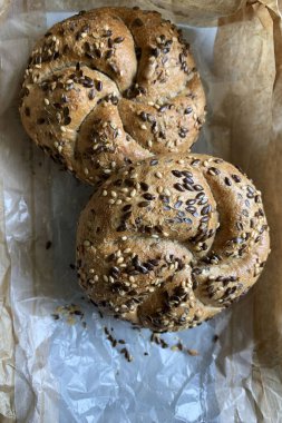 Kurabiye kağıdında tohum olan iki yeni pişmiş çörek. Genel bakış. Ev yapımı konsept.