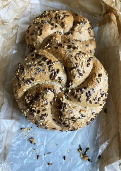 Kurabiye kağıdında tohum olan iki yeni pişmiş çörek. Genel bakış. Ev yapımı konsept.