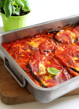 Fırında patlıcan dilimleri, domates sosu, mozzarella, parmesan peyniri ve fesleğen. Ev yapımı yemek konsepti. Genel bakış. Boşluğu kopyala.