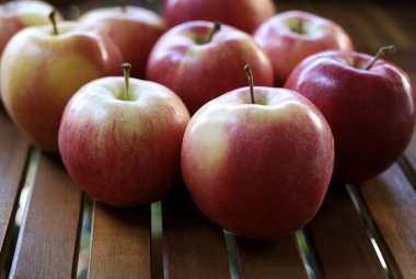 Tahta arka planda bir grup taze kırmızı elma meyvesi. Vejetaryen ve sağlıklı yiyecekler. Yakın plan. Boşluğu kopyala.