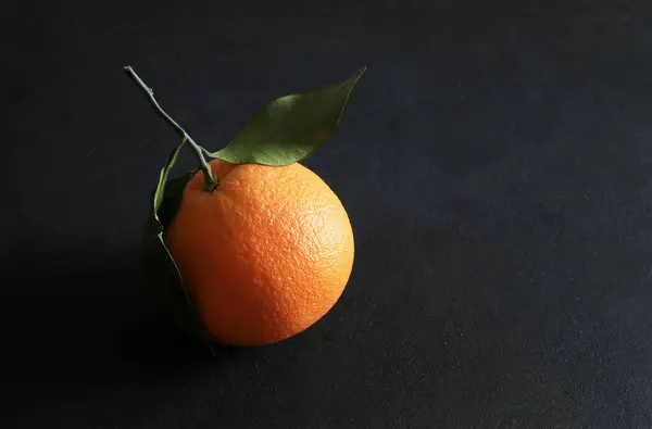 Fresh orange with leaves isolated on black  background. Healthy and vegetarian food. Close-up. Copy space.