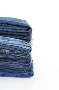 Beyaz arka planda izole edilmiş mavi kot yığını. Moda kıyafet konsepti. Yakın plan..