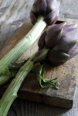 Tahta arka planda taze organik enginarlar. Sağlıklı ve vejetaryen yemekleri. Genel bakış. Boşluğu kopyala.