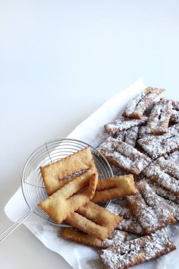 Ev yapımı geleneksel İtalyan karnaval tatlıları: Beyaz arka planda chiacchiere. Boşluğu kopyala. 