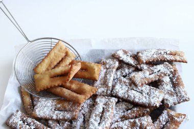 Ev yapımı geleneksel İtalyan karnaval tatlıları: Beyaz arka planda chiacchiere. Boşluğu kopyala. 