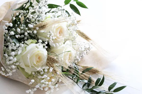 Elegant white roses and babies breath bouquet isolated on white background. Wedding, Valentine\'s day, birthday, mother\'s day, anniversary. Fresh flowers. Flat lay. Overhead view. Copy space.