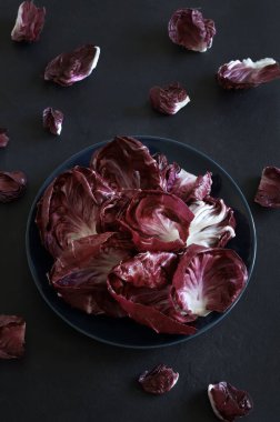 Kırmızı turşu yaprakları koyu arkaplanda yalıtılmış. Vejetaryen ve sağlıklı yiyecekler. Genel bakış. Boşluğu kopyala.