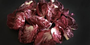 Kırmızı turşu yaprakları koyu arkaplanda yalıtılmış. Vejetaryen ve sağlıklı yiyecekler. Genel bakış. Boşluğu kopyala.