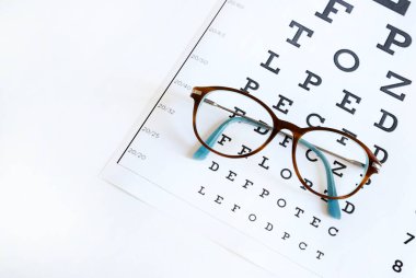 Gözlük ve göz çizelgesi beyaz arka planda izole edilmiş. Moda ve göz sağlığı. Boşluğu kopyala.