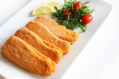 Beyaz arka planda salata ve limonlu kızarmış balık filetosu. Genel bakış. Boşluğu kopyala.
