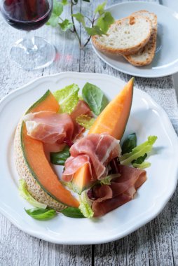İtalyan mezesi. Çiğ jambon ve Toskana ekmeği dilimlenmiş kavun. Yaz yemeği. Yakın plan..