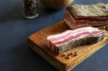 Tahta kesme tahtasının üzerinde gerilmiş domuz göbeği, gri arka plan. Genel bakış. Boşluğu kopyala.