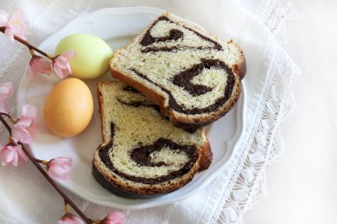 Cozonac, Romanya geleneksel cevizli tatlı ekmek ve beyaz arka planda iki Paskalya yumurtası. Paskalya tatili konsepti.