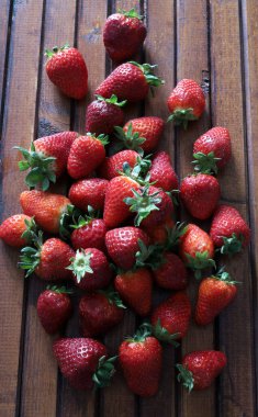 Ahşap arka planda bir sürü taze çilek var. Sağlıklı ve vejetaryen yemekleri. Tam üstte. Boşluğu kopyala.