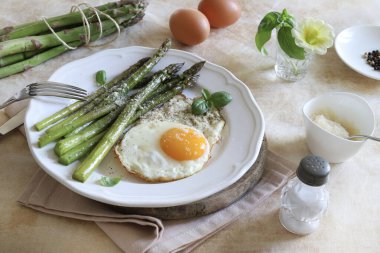 Yeşil kuşkonmaz ve üzerine parmesan serpiştirilmiş yumurta. Sağlıklı yiyecekler. Kahvaltı konsepti. Tam üstte.