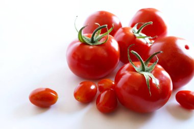 Beyaz arka planda izole edilmiş bir grup taze domates. Sağlıklı ve vejetaryen yemekleri. Boşluğu kopyala.