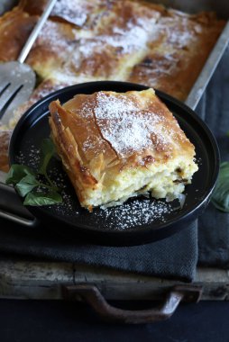 Yunan mutfağı. Ev yapımı geleneksel Yunan Bougatsa 'sı, peynirle doldurulmuş fillo hamur işi ve üzerine şeker serpiştirilmiş. Tam üstte.
