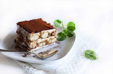 İtalyan kahvesi tiramisusu. Beyaz arka planda kadın parmaklı ve maskaralık kremalı klasik kahve tiramisusu. İtalyan tatlısı.