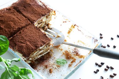 İtalyan kahvesi tiramisusu. Beyaz arka planda kadın parmaklı ve maskaralık kremalı klasik kahve tiramisusu. İtalyan tatlısı.