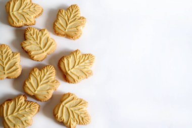 Klasik Kanada akçaağaç yaprağı şekilli kurabiyeler. Beyaz arka planda izole edilmiş iki çıtır kurabiyenin arasına sıkıştırılmış akçaağaç kreması. Boşluğu kopyala.