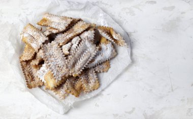 Ev yapımı geleneksel İtalyan karnaval tatlıları: Beyaz arka planda chiacchiere. Uzayı kopyala Tam üstte.