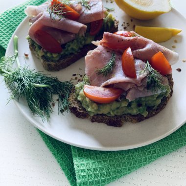 Fırında jambonlu avokado tostu (prosciutto) ve beyaz arka planda domates. Sağlıklı gıda konsepti. Genel Görünüm.