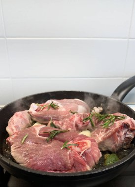 Tavada otlarla birlikte ev yapımı kuzu rostosu. Tam üstte. 