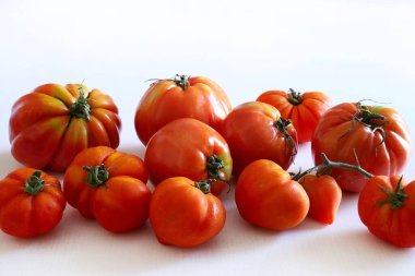 Beyaz arka planda izole edilmiş bir grup taze domates. Sağlıklı ve vejetaryen yemekleri. Boşluğu kopyala.