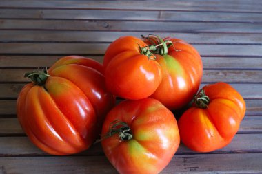 Tahta bir arka planda izole edilmiş bir grup taze domates. Sağlıklı ve vejetaryen yemekleri. Boşluğu kopyala.