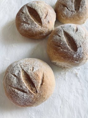 Un beyazı bir masada izole edilmiş taze pişmiş çörekler. Tam üstte.