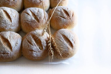 Taze ev yapımı çörekler ve buğday kulakları olan bir arka plan. Tam üstte.