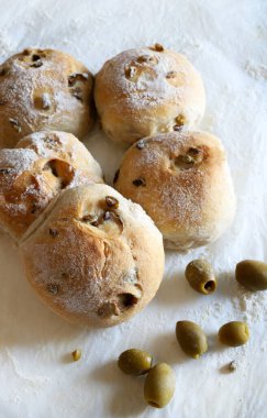 Beyaz arka planda zeytinli taze pişmiş çörekler. Tam üstte.