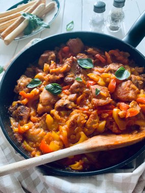 Ahşap masadaki tepside biberli ve domates soslu ev yapımı tavuk nuggetları. Tam üstte.