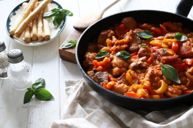 Ahşap masadaki tepside biberli ve domates soslu ev yapımı tavuk nuggetları. Tam üstte.