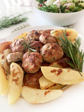 Ev yapımı köfte, fırında patates ve taze salata. Tam üstte.