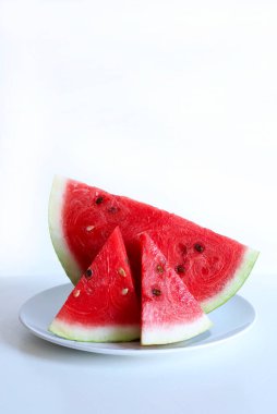 Beyaz ahşap arka planda yarım karpuz ve karpuz dilimleri. Sağlıklı yaz meyvesi.