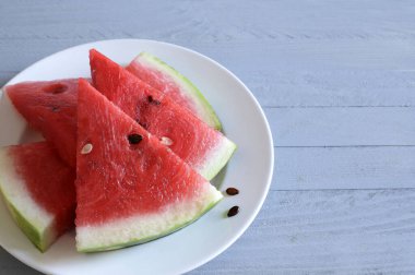 Gri ahşap masada izole edilmiş karpuz dilimleri. Sağlıklı yaz meyvesi.