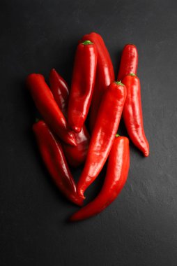 Karanlık arka planda izole edilmiş bir grup taze boynuz biberi. Sağlıklı ve vejetaryen yemekleri. Tam üstte.