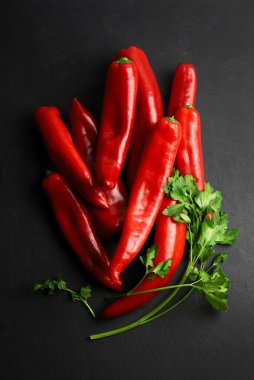 Karanlık arka planda izole edilmiş bir grup taze boynuz biberi. Sağlıklı ve vejetaryen yemekleri. Tam üstte.