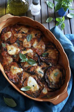 Fırında patlıcan parmigiana. Patlıcan, domates püresi, fesleğen, sarımsak ve peynir tabanlı bir tabak. Taze fesleğen yaprakları süsleme. İtalyan yemeği. Tam üstte.