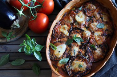 Fırında patlıcan parmigiana. Patlıcan, domates püresi, fesleğen, sarımsak ve peynir tabanlı bir tabak. Taze fesleğen yaprakları süsleme. İtalyan yemeği. Tam üstte.