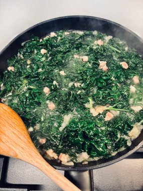 Siyah tavada sotelenmiş lahana, domuz pastırması küpleri ve mutfak sobasında zeytinyağı. Sağlıklı aşçılık kavramı. Ev yapımı doğal yiyecekler.. 