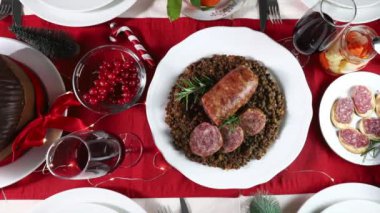 Geleneksel İtalyan Noel yemeği. Mercimek, meze, meyve, kırmızı şarap ve Panettone ile Cotechino. Aile toplantısı konsepti. Tam üstte.